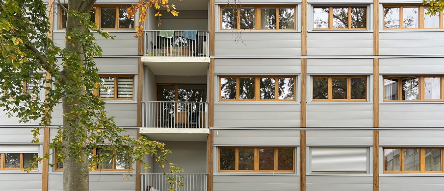 La nouvelle façade de la résidence dont les panneaux ont été préfabriqué en usine. Les panneaux sont couleur gris et bois.