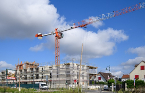 Vue d'ensemble de la future résidence, entourée d'échafaudages et avec une grue en surplomb.