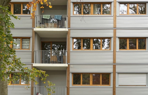 La nouvelle façade de la résidence dont les panneaux ont été préfabriqué en usine. Les panneaux sont couleur gris et bois.